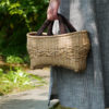 ナチュラルカラーの竹バッグを持つ女性