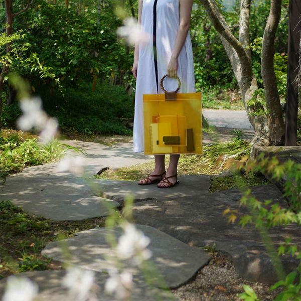 黄色の竹バッグを持つ女性