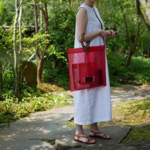 赤色の竹バッグを持つ女性